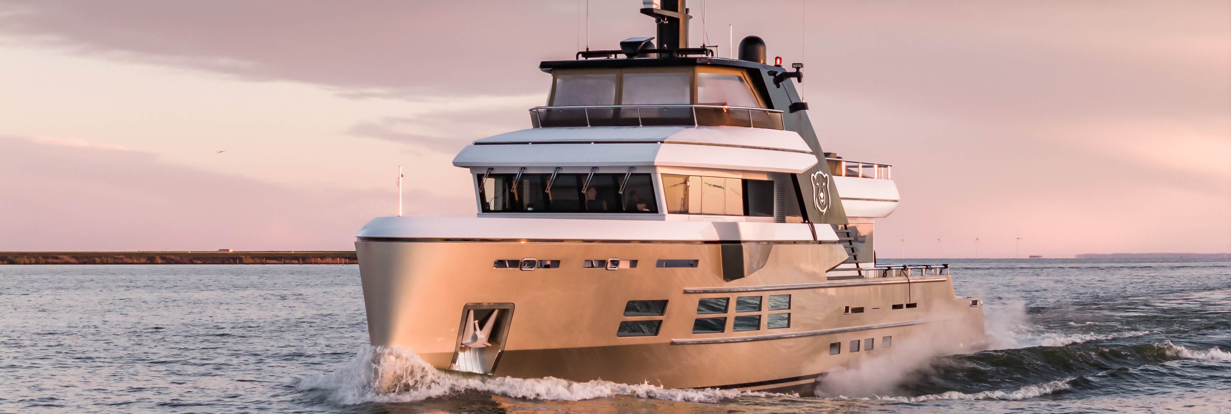 A refit superyacht with sleek lines cruising at dawn