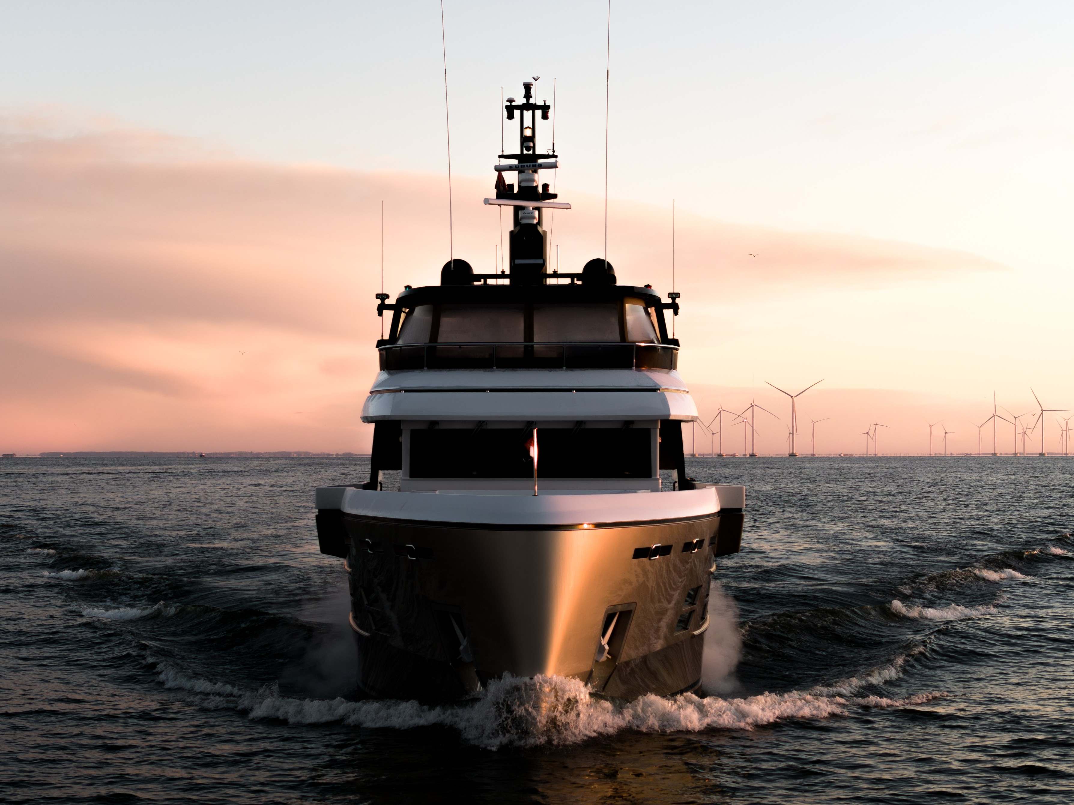 A refit superyacht with sleek lines cruising at dawn